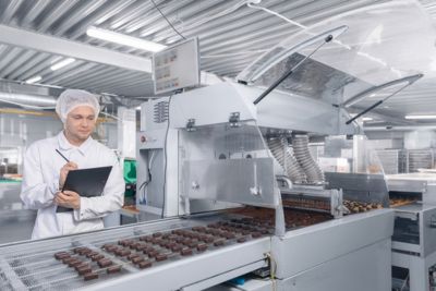 Personne travaillant dans une usine de chocolats industriels.
